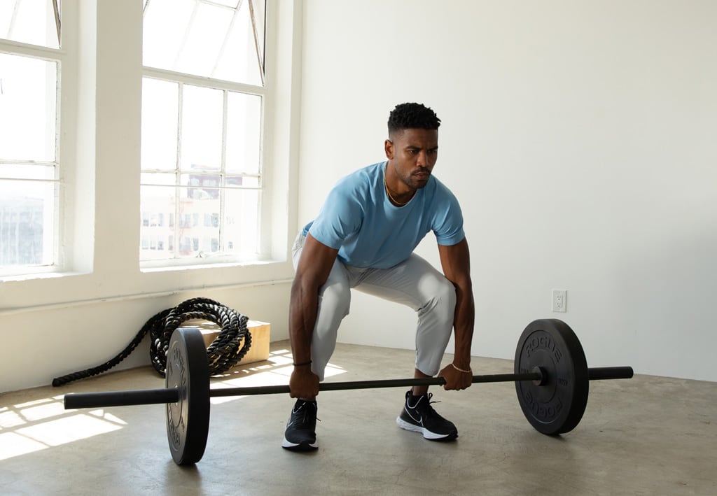 Coach deadlifting inside a gym